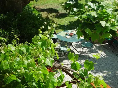 a blue table and chairs in a garden at Hôtel Le Mas des Grès & Restaurant Sous les Platanes in Lagnes
