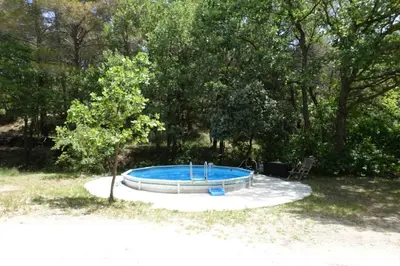 a small swimming pool in a yard with a tree at L'Enclos in Aix-en-Provence