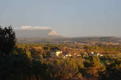 a mountain in the distance with a town and trees at L'Enclos in Aix-en-Provence