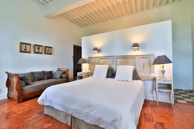 a bedroom with a large bed and a couch at Le Jardin de Mazan in Mazan