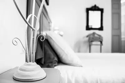 a white vase sitting on a table next to a bed at Le Jardin de Mazan in Mazan