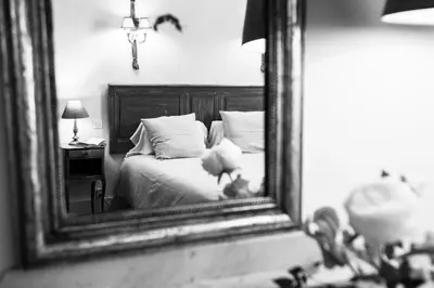 a bedroom with a bed and a mirror at Le Jardin de Mazan in Mazan