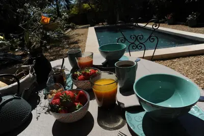 a table with bowls of fruit and drinks on it at Le Jardin de Mazan in Mazan