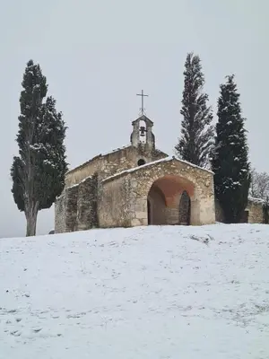 an old church with a cross on top of a snow covered field at La Sarriette - Chambres d'hôtes et gîte d'étape à Eygalières in Eygalières