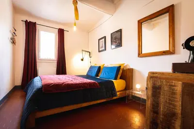 a bedroom with a bed and a mirror on the wall at Lumineux Aix Plein Centre avec Parking privé Gratuit in Aix-en-Provence