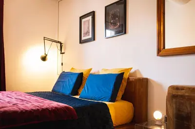 a bedroom with a bed with blue and yellow pillows at Lumineux Aix Plein Centre avec Parking privé Gratuit in Aix-en-Provence