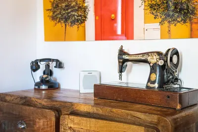an old sewing machine sitting on top of a wooden dresser at Lumineux Aix Plein Centre avec Parking privé Gratuit in Aix-en-Provence