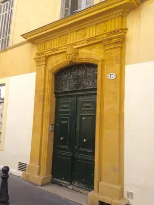 a large black door on the side of a building at Lumineux Aix Plein Centre avec Parking privé Gratuit in Aix-en-Provence