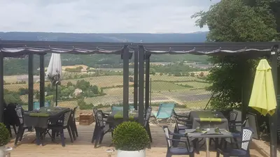 a patio with tables and chairs with a view at Hotel Belvue in Sault-de-Vaucluse