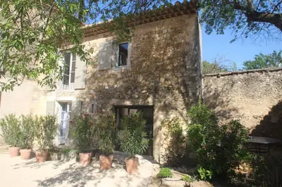 an old stone building with potted plants in front of it at Les Guillaume Rey in Oppède