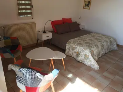 a bedroom with a bed and a table and chairs at Luberon & Lavandes in Roussillon