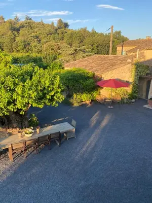 a group of picnic tables and a red umbrella at Mas Serena in Ménerbes