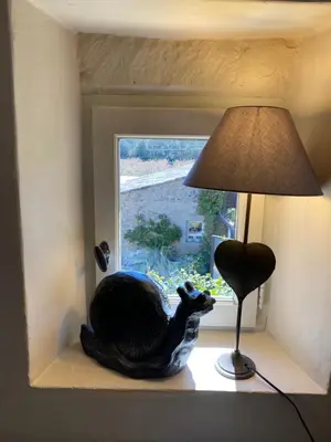 a bird statue sitting on a window sill next to a lamp at Mas Serena in Ménerbes