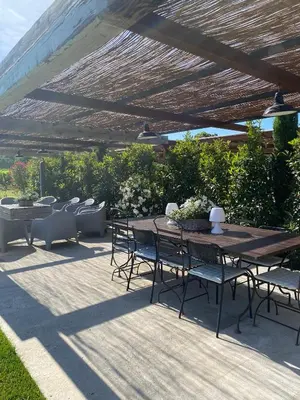 a patio with a table and chairs under a pergola at Mas Serena in Ménerbes