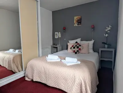 a bedroom with two beds and a mirror at L'Aiguebelle in Céreste