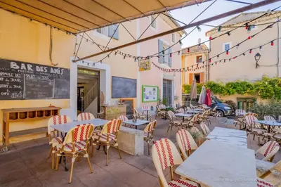 a restaurant with tables and chairs and a chalkboard at Bar des Amis in Villars