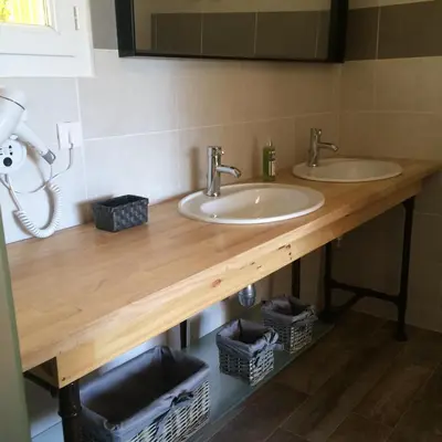 two sinks on a wooden counter in a bathroom at Mas Auroma in Murs