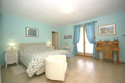 a blue bedroom with a bed and a desk at Les Cerises in Saint-Saturnin-les-Apt