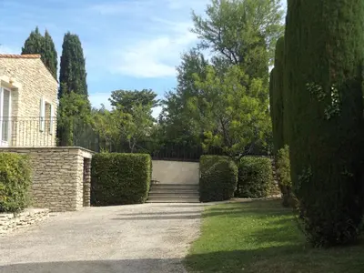 a driveway leading to a house with hedges at Bastidon la Cicada in Gordes