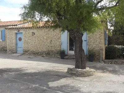 a brick building with a tree in front of it at Bastidon la Cicada in Gordes