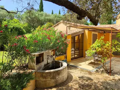 a house with a garden with a fountain in the yard at Le Chant du Coeur in Roussillon