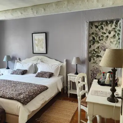 a bedroom with a large white bed and two tables at Le Chant du Coeur in Roussillon