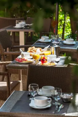 a table with plates of food and drinks on it at Hôtel Le Mozart in Aix-en-Provence