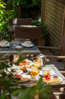 a table with plates of food and glasses of orange juice at Hôtel Le Mozart in Aix-en-Provence
