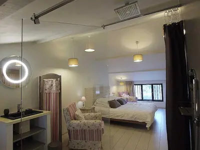 a bedroom with a bed and a table and a chair at Couleur Lavande in Le Thor