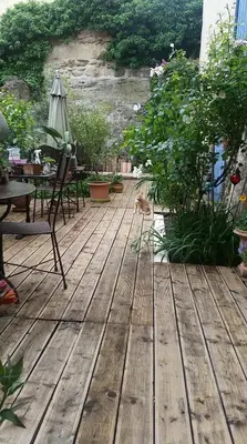 a cat is sitting on a wooden deck at Gîte en Provence in Entraigues-sur-la-Sorgue
