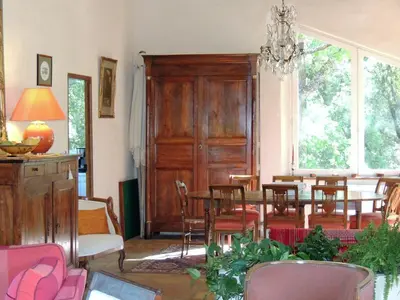 a dining room with a table and chairs and a chandelier at Les Chênes Verts in La Bastidonne