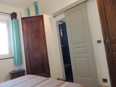 a bedroom with a bed and a closet and a door at Les Chênes Verts in La Bastidonne