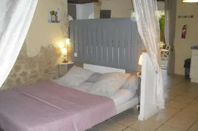 a bedroom with a bed with a gray headboard at Lou mas li Pitchoun 
