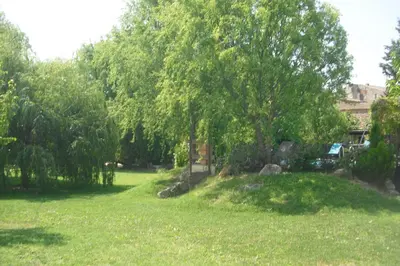 a park with trees and grass and a building at Lou mas li Pitchoun 