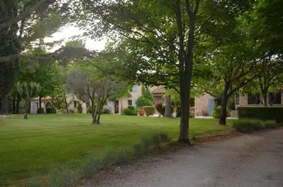 a field of green grass with trees in front of a house at Campagne Chastel in Aix-en-Provence