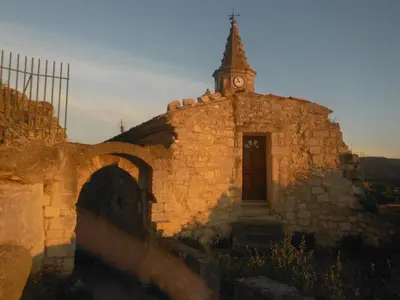 an old stone building with a clock tower on it at Appartement Le Romarin in Mallemort