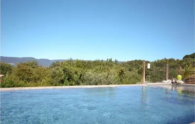 a swimming pool with blue water and trees in the background at 2 Bedroom Stunning Home In Apt in Apt