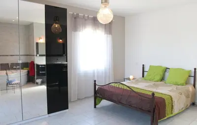 a bedroom with a bed with green pillows and a bathroom at 4 Bedroom Awesome Home In Apt in Apt