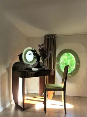 a table with a mirror and a chair in a room at La Buissonnière in Oppède