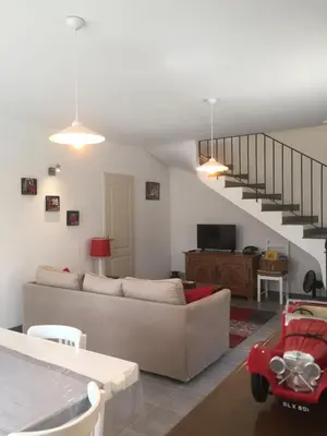 a living room with a couch and a staircase at Maison de vacances Jocelyne in Lauris