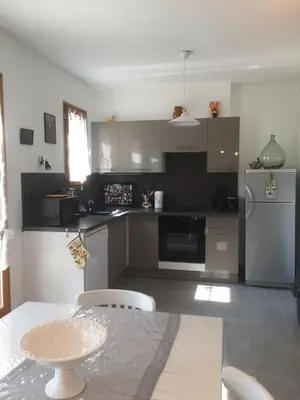 a kitchen with stainless steel appliances and a table at Maison de vacances Jocelyne in Lauris