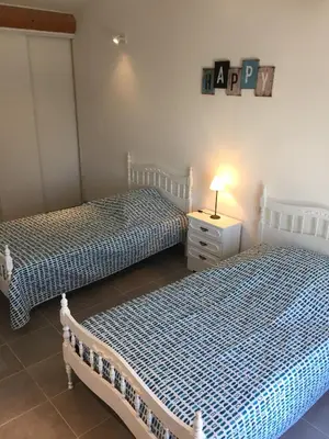 two beds in a bedroom with a night stand and a lamp at Maison de vacances Jocelyne in Lauris