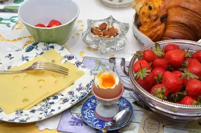 a table with strawberries and eggs and a plate of food at Les chambres d'Adeline - B&B in Murs