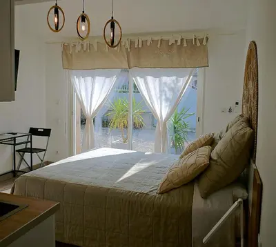 a bedroom with a bed and a large window at Villa hortensia in Carpentras