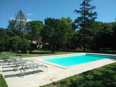 a swimming pool with lounge chairs next to a field at Lou Vergié Maison Provencale au pied du Luberon in Saint-Martin-de-Castillon