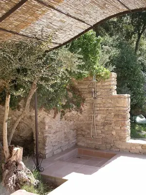 an old stone building with stairs and a plant at La Baumo 1 und 2 in Le Beaucet