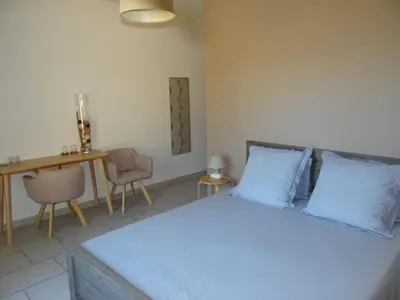 a bedroom with a bed with blue pillows and a table at Campagne Cérès in Le Puy-Sainte-Réparade