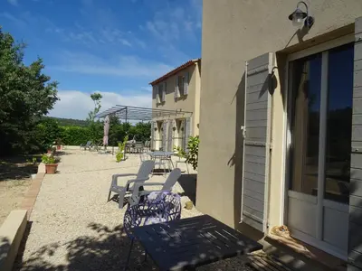 a patio with chairs and tables and a building at Campagne Cérès in Le Puy-Sainte-Réparade