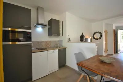 a kitchen with a wooden table and a dining room at B&B La Badelle in Gordes