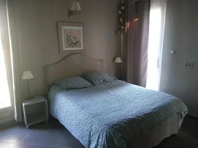 a bedroom with a bed with a blue comforter and a window at maison près de l'eau in LʼIsle-sur-la-Sorgue
